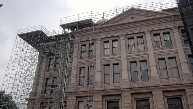 Construction on the side of the Texas state capitol building with close up video panning left to right.