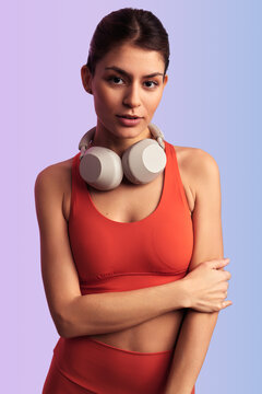 Confident sportswoman with headphones around neck