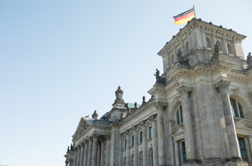 The Bundestag building, Parliament of the Federal Republic of Germany, with German flag flying outside.