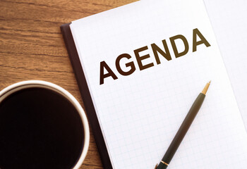 AGENDA text on a notepad with coffee and pen on wooden background