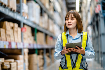 Women warehouse worker using digital tablets to check the stock inventory on shelves in large warehouses, a Smart warehouse management system, supply chain and logistic network technology concept