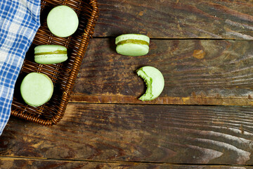 French pistachio macarons in basket on wood table 