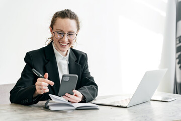 A lawyer is a smart woman with glasses, an entrepreneur using a computer for online work in the office.