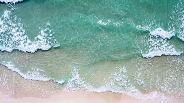 Foamy azure waves washing up on white sand Haad rin beach, Thailand.