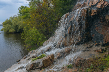 Waterfall Loud threshold on the slope of the Monastery Island in the Dnieper, Ukraine. Artificial decorative waterfall.