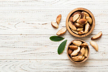Fresh healthy Brazil nuts in bowl on colored table background. Top view Healthy eating bertholletia concept. Super foods