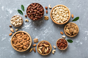 mixed nuts in wooden bowl. Mix of various nuts on colored background. pistachios, cashews, walnuts, hazelnuts, peanuts and brazil nuts