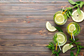 Caipirinha, Mojito cocktail, vodka or soda drink with lime, mint and straw on table background. Refreshing beverage with mint and lime in glass top view flat lay