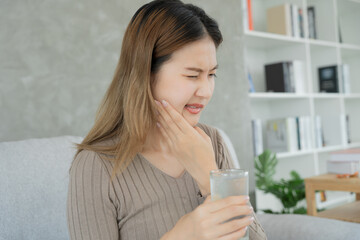 Asian woman feel sensitive teeth after drinking cold, female suffer tooth, decay problems, dental care, tooth extraction, decay problem, bad breath, Gingival Recession, Oral Hygiene instruction