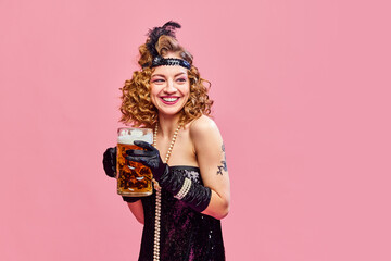 Close up portrait of happy smiling woman in retro style dress drinking fresh lager beer with pleasure over pink background. Oktoberfest, festival