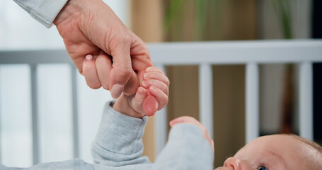 Close-up of hand of mother and infant at children room background. Concept of motherly love, new...