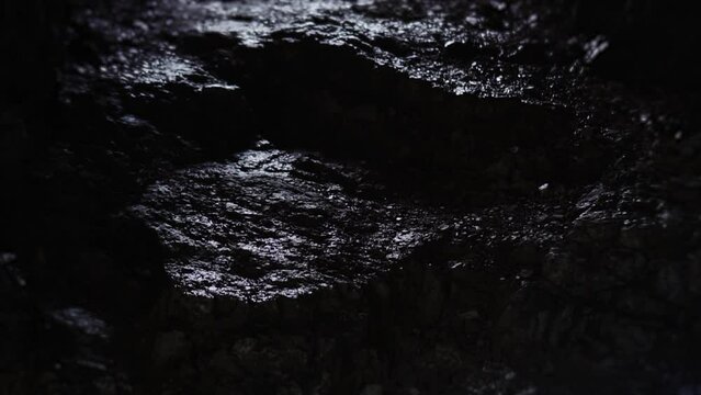 Dark corridor and water drops falling down in mountain cave