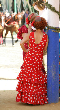 Feria de Sevilla, flamencas echada en poste de luz.