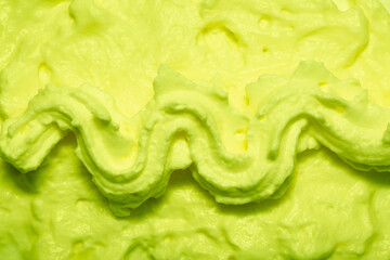 Cake cream texture, sweet whipped cream. Background of yogurt close-up with a pattern. Pistachio mousse.