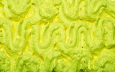 Cake cream texture, sweet whipped cream. Background of yogurt close-up with a pattern. Pistachio mousse.
