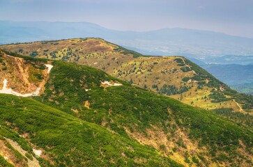 Obraz premium Mountain landscape in spring season. Picturesque view stretches of the highest peak in Beskids mountains (Babia Gora) over trail running the ridge, Poland.