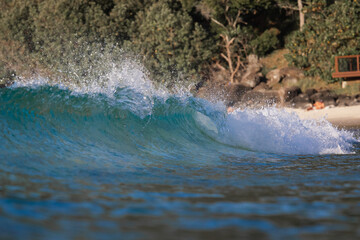 Obraz premium Beautiful wave breaking on the beach shore.