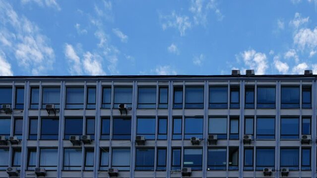 Shooting the active movement of clouds over the city on a summer day. The lamp blums in the building