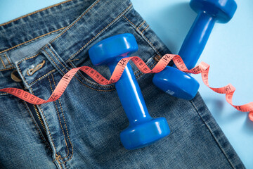 Jeans with measuring tape and dumbbells.