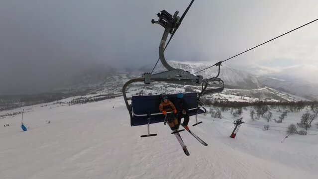 Young disabled boy taking ski-lift using sitski foir handicapped