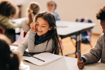 Small girl laughs happily in a primary school class