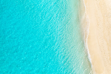 Top drone view travel landscape. Summer sunrise seascape waves, blue sea water yellow sand. Aerial amazing tropical nature background. Beautiful bright sea waves splashing and beach sand sunset light