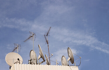 Satellite dishes and digital terrestrial television on a roof of a big city. Copy space