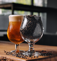 glass of beer and wheat in glass on wooden table