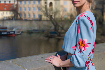 Young woman in a bright dress on the embankment of the Vltava River in Prague, Czech Republic