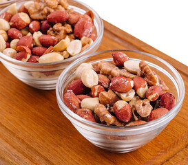 Assorted nuts in a glass bowls on wooden