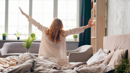 Caucasian woman waking up in morning in cozy bed on soft orthopedic mattress stretches start new...