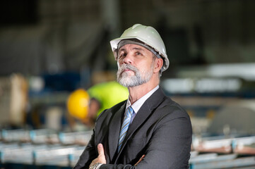 older owner engineer with beard mustache on face standing smile with his arms crossed at...