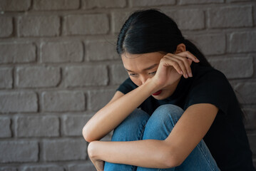 depressing woman is hugging knees on the floor. sad woman hug her knee and cry sitting alone in empty room. alone sadness anxiety grief girl sit hugging knees