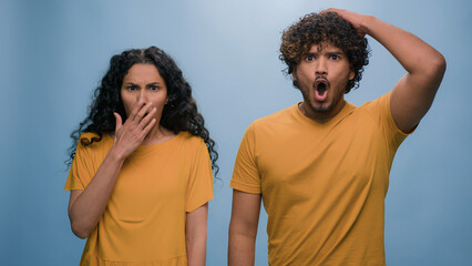Multiracial couple amazed shocked Hispanic woman girl Indian man guy astonishment wonder blue...
