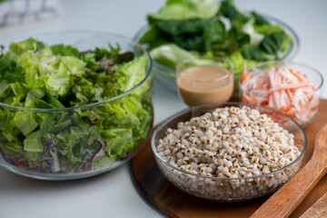Hand cut and slice fresh baby cos salad on wood board table .Organic Vegetables mix lunch with green vegetables at kitchen table on wood cutting board.