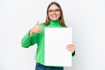 Naklejka premium Young caucasian woman isolated on white background holding an empty placard with thumb up