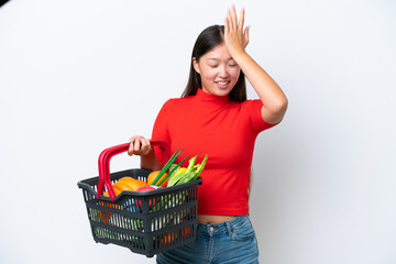 Young Asian woman holding a shopping basket full of food isolated on white background has realized something and intending the solution