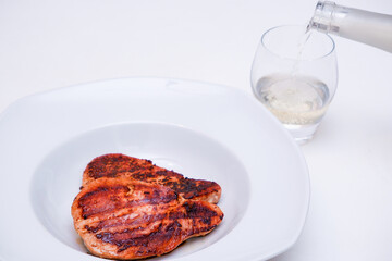 Dinner with seafood and vine. Close Up Still Life of Two Fried Tuna Steaks on Plate with Glass of White Vine
