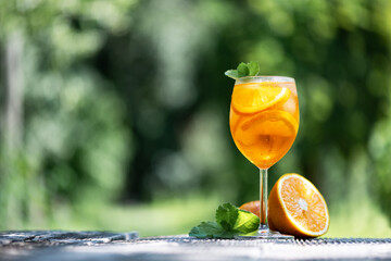 Aperol Spritz Aperitivo summer cocktail drink in original glass with oranges and mint twig on...