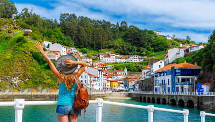 Traveler woman tourist enjoying beautiful fishing village in Asturias, Cudillero in Spain - obrazy, fototapety, plakaty