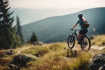 Fototapeta na wymiar Young woman riding mountain bike in mountains, forest landscape