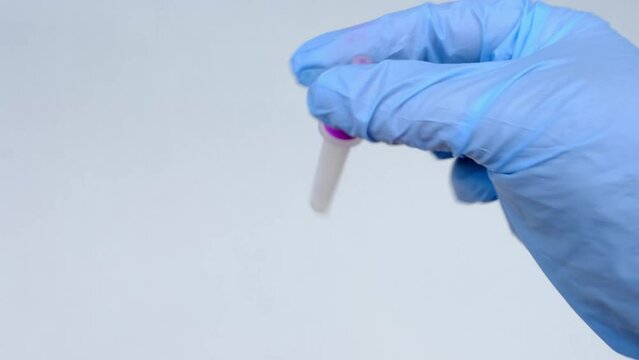 assistant makes express test in medical scientific laboratory, stirs sample of genetic sample, material in plastic tube, concept of determining ethnic origin, paternity, covid-19 infection