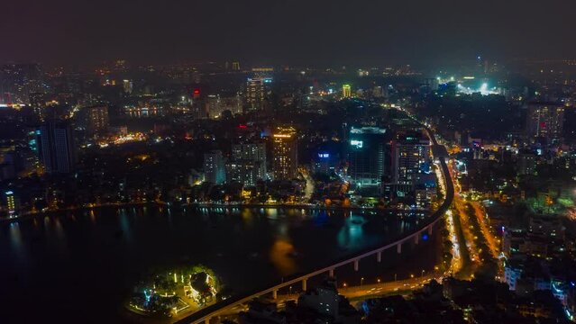 HANOI, VIETNAM - MAY, 2023: Night aerial drone view timelapse of a city streets in downtown nightlife traffic from a top view.