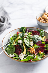 Healthy Salad made from Green Salad Leaves, Rocket Salad, Slices of Beetroot, Avocado, pieces of Feta Cheese, Walnuts and Sesame Seeds.