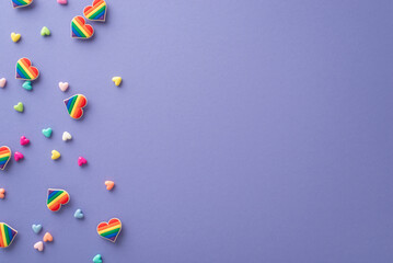 This top view flat lay of symbolic accessories for a pride parade on lilac backdrop with space for text or advertising represents the idea of promoting love, diversity, and inclusivity in our society