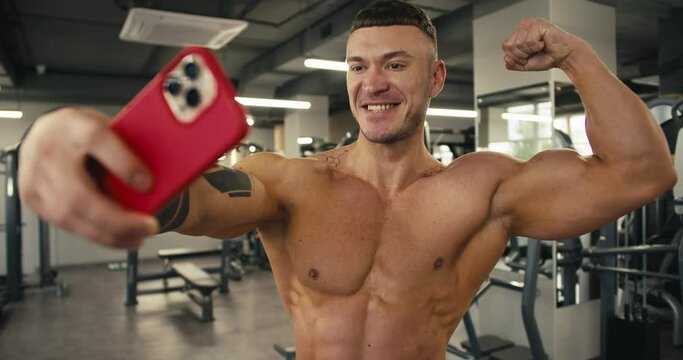 A young athlete takes photos of himself and takes selfies to post them on a social network. The results of long work in the gym