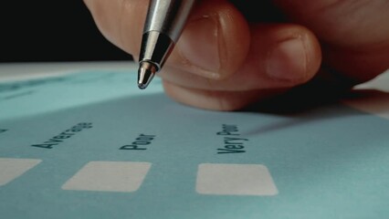 Closeup macro shot movement hand filling feedback survey form with pen for customer satisfaction. Questionnaire form get excellent rating feedback as marketing and quality evaluation concept.
