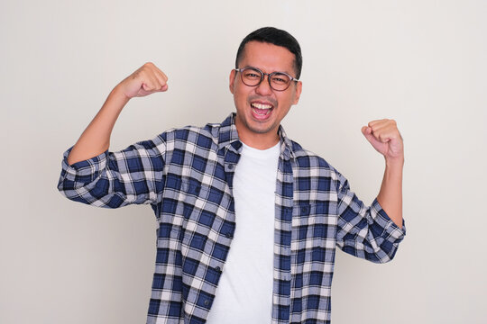 Adult Asian man screaming and showing his biceps muscle