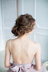 Evening hairstyle for a girl with a bare back