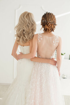 Two brides with different hairstyles hold each other